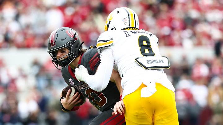 Nov 22, 2025; Norman, Oklahoma, USA;  Oklahoma Sooners quarterback John Mateer (10) is tackled by Missouri Tigers defensive end Damon Wilson II (8) during the first half at Gaylord Family-Oklahoma Memorial Stadium. Mandatory Credit: Kevin Jairaj-Imagn Images