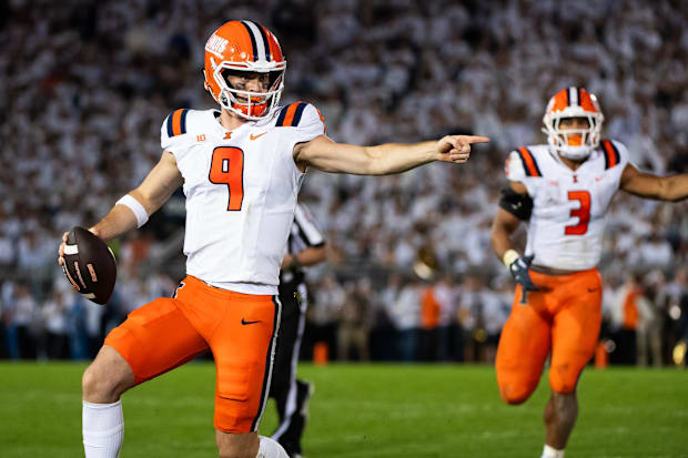 Illinois quarterback Luke Altmyer (9) points to one of his blockers as he runs with the ball.