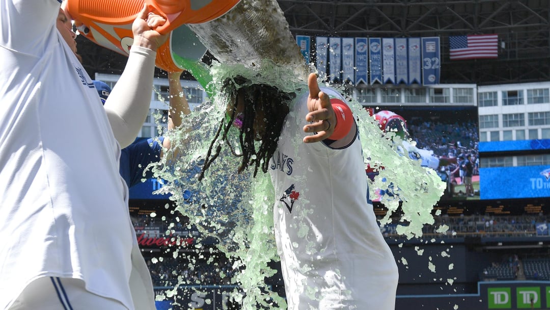 Jun 6, 2024; Toronto, Ontario, CAN;    Toronto Blue Jays first baseman Vladimir Guerrero Jr. (27) is doused in sports drink as he celebrates a win over the Baltimore Orioles at Rogers Centre. Mandatory Credit: Dan Hamilton-USA TODAY Sports