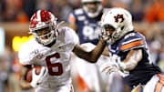 Alabama wide receiver DeVonta Smith (6) attempts to fend off a tackle by Auburn defensive back Jeremiah Dinson (20) during the Iron Bowl in Jordan-Hare Stadium on Nov. 30, 2019.