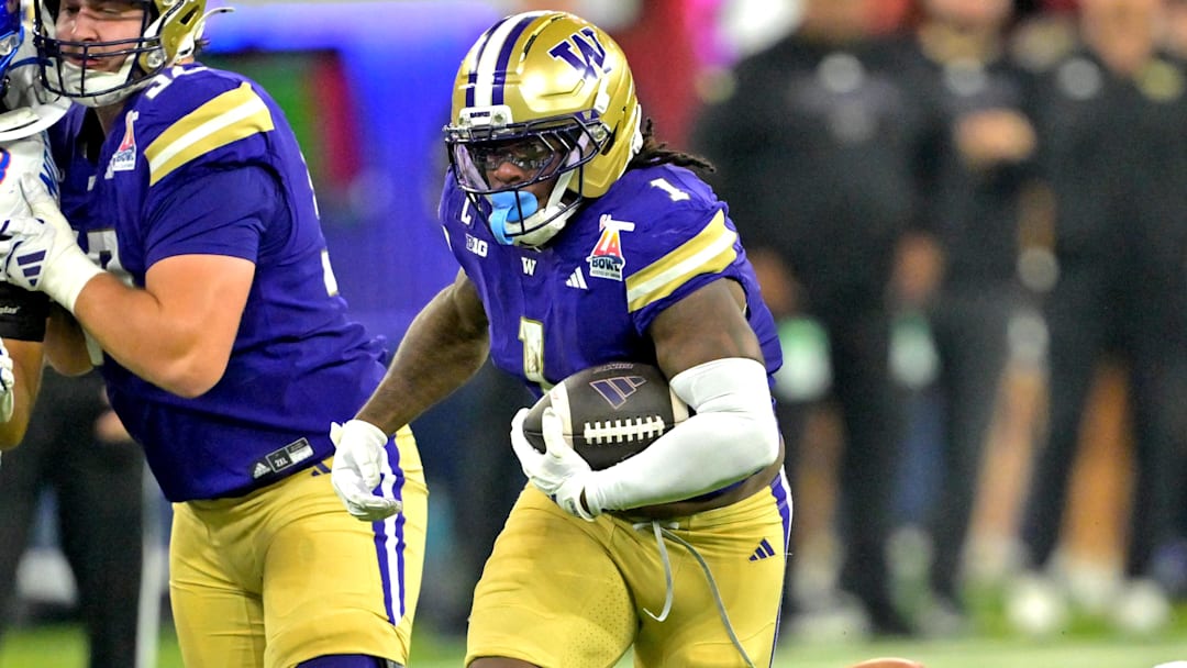 Dec 13, 2025; Inglewood, CA, USA;  Washington Huskies running back Jonah Coleman (1) carries past Boise State Broncos wide receiver Cameron Bates (80) for a first down in the first half of the LA Bowl at SoFi Stadium. Mandatory Credit: Jayne Kamin-Oncea-Imagn Images