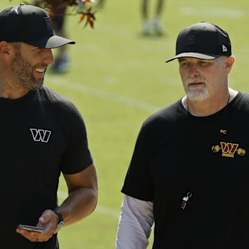 Washington Commanders general manager Adam Peters talks with Commanders head coach Dan Quinn.
