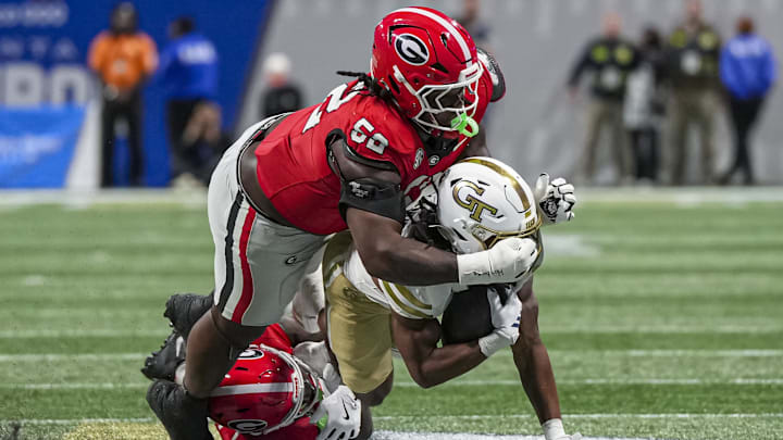 Nov 28, 2025; Atlanta, Georgia, USA; Georgia Tech Yellow Jackets running back Chad Alexander (27) is tackled by Georgia Bulldogs defensive lineman Christen Miller (52) and safety Zion Branch (2) during the second half at Mercedes-Benz Stadium. Mandatory Credit: Dale Zanine-Imagn Images