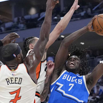 Apr 13, 2025; Milwaukee, Wisconsin, USA; Milwaukee Bucks forward Chris Livingston (7) puts up a shot against Detroit Pistons forward Lindy Waters III (43) and Detroit Pistons forward Paul Reed (7) in the first half at American Family Field. Mandatory Credit: Michael McLoone-Imagn Images