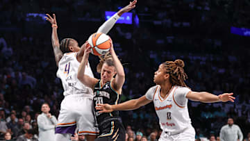New York Liberty guard Sabrina Ionescu drives past Phoenix Mercury forward Natasha Mack and guard Monique Akoa Makani