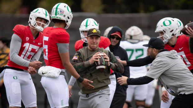 Oregon’s quarterbacks pressure offensive coordinator Will Stein as he runs through a drill during practice with the Oregon Du