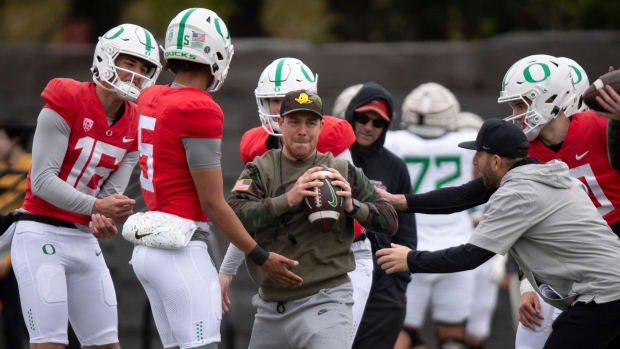 Oregon’s quarterbacks pressure offensive coordinator Will Stein as he runs through a drill during practice with the Oregon Du