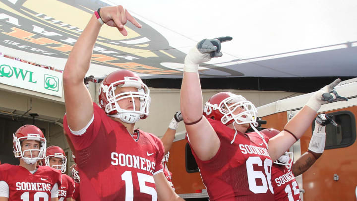 Oklahoma Sooners players give the 'Horns Down' gesture before a game against the Texas Longhorns. Both schools enter the SEC as part of college football's conference realignment in 2024.