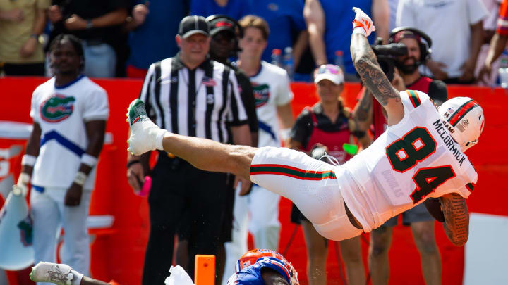 Florida Gators defensive back Jordan Castell (14) upends Miami Hurricanes tight end Cam McCormick (84) as he scores a touchdown during the season opener at Ben Hill Griffin Stadium in Gainesville, FL on Saturday, August 31, 2024 against the University of Miami Hurricanes in the first half. [Doug Engle/Gainesville Sun]