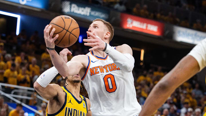 May 17, 2024; Indianapolis, Indiana, USA; New York Knicks guard Donte DiVincenzo (0) shoots the ball while Indiana Pacers guard Andrew Nembhard (2) defends during game six of the second round for the 2024 NBA playoffs at Gainbridge Fieldhouse. Mandatory Credit: Trevor Ruszkowski-Imagn Images