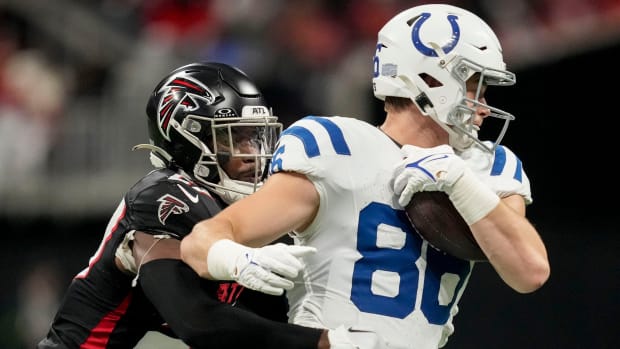 Colts tight end Will Mallory (white jersey/helmet with blue trim) tries to get away from a defensive player. 