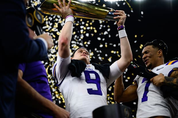 LSU quarterback Joe Burrow (9) holds up the trophy after their victory against Clemson.