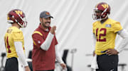 Jun 8, 2023; Ashburn, Virginia, USA; Washington Commanders quarterbacks coach Tavita Pritchard (M) talks to Commanders quarterback Sam Howell (14) and Commanders quarterback Jacoby Brissett (12) during day three of minicamp at OrthoVirginia Training Center at Commanders Park, held inside the training bubble due to poor air quality from Canadian wildfire smoke in Ashburn. Mandatory Credit: Geoff Burke-Imagn Images