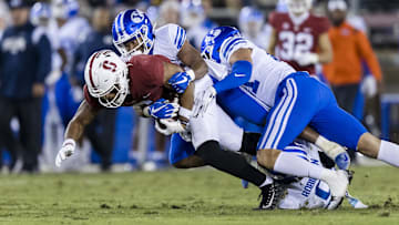 Nov 26, 2022; Stanford, California, USA;  Stanford Cardinal wide receiver Elijah Higgins (6) is tackled by Brigham Young Cougars defensive back Micah Harper (1) during the first half at Stanford Stadium. Mandatory Credit: John Hefti-Imagn Images