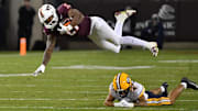 Oct 24, 2025; Blacksburg, Virginia, USA;  Virginia Tech Hokies running back Tyler Mason (23) goes airborne after a hit by California Golden Bears defensive back Brent Austin (4) at Lane Stadium. Mandatory Credit: Brian Bishop-Imagn Images