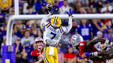 Sep 7, 2024; Baton Rouge, Louisiana, USA; Nicholls State Colonels quarterback Pat McQuaide (7) rolls out of the pocket against LSU Tigers linebacker Harold Perkins Jr. (7) during the second half at Tiger Stadium.