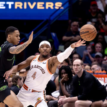 Apr 5, 2024; New Orleans, Louisiana, USA; San Antonio Spurs guard Devonte' Graham (4) passes the ball against New Orleans Pelicans guard Jordan Hawkins (24) during the first half at Smoothie King Center. Mandatory Credit: Stephen Lew-USA TODAY Sports