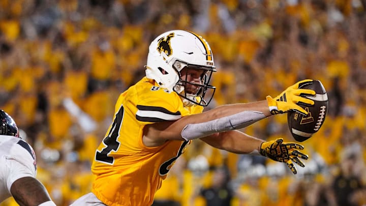 Sep 2, 2023; Laramie, Wyoming, USA; Wyoming Cowboys tight end John Michael Gyllenborg (84) scores a touchdown in double overtime against the Texas Tech Red Raiders at Jonah Field at War Memorial Stadium. Mandatory Credit: Troy Babbitt-Imagn Images