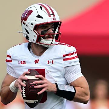 Nov 15, 2025; Bloomington, Indiana, USA; Wisconsin Badgers quarterback Carter Smith (5) looks for an open teammate during the first quarter against the Indiana Hoosiers at Memorial Stadium.