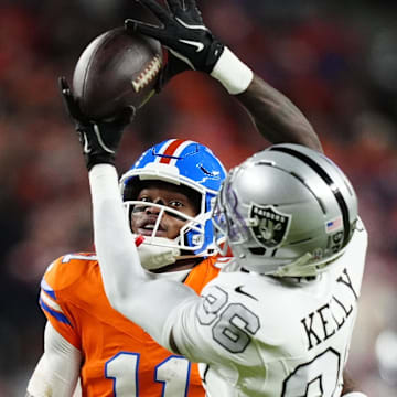 Nov 6, 2025; Denver, Colorado, USA; Las Vegas Raiders cornerback Kyu Blu Kelly (36) intercepts a pass for Denver Broncos wide receiver Troy Franklin (11) during the first half at Empower Field at Mile High. Mandatory Credit: Ron Chenoy-Imagn Images