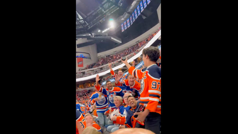 Oilers fans react after a young fan recovers an errant puck during Game 1 of the Stanley Cup Finals. | Bleacher Report / X / Screensho