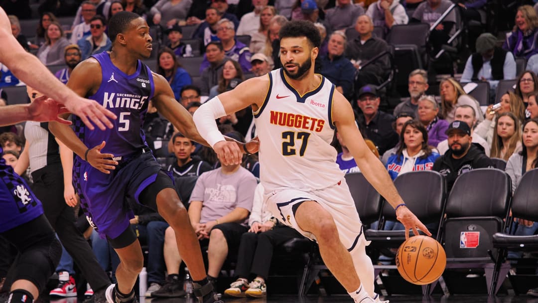 Feb 9, 2024; Sacramento, California, USA; Denver Nuggets guard Jamal Murray (27) controls the ball against Sacramento Kings guard De'Aaron Fox (5) during the first quarter at Golden 1 Center. Mandatory Credit: Kelley L Cox-USA TODAY Sports