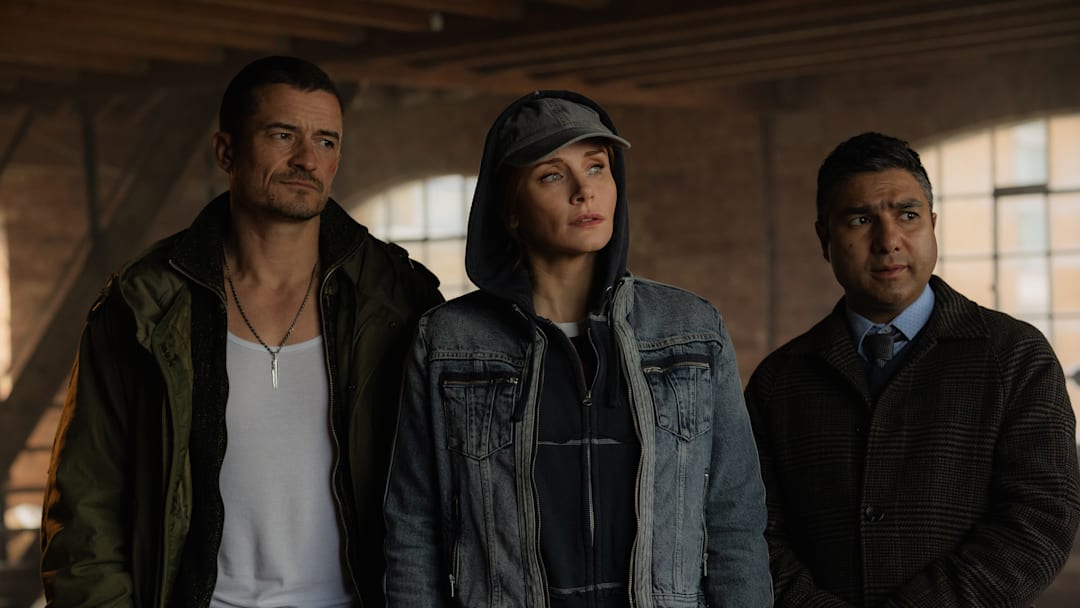Orlando Bloom as MARLON, Bryce Dallas Howard as KAT, Nick Mohammed as HUGH in DEEP COVER. Credit: Peter Mountain / © 2025 COPERTURA PRODUCTIONS LTD. ALL RIGHTS RESERVED.