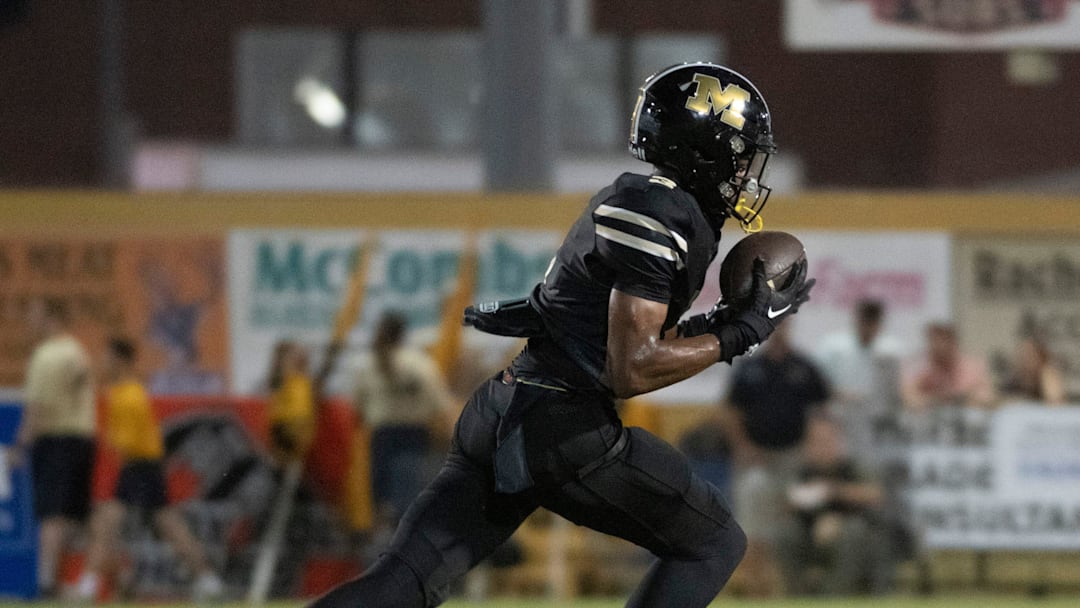 Milton's Kaiden Hall No. 3) pulls in the pass for a huge gain against the Gulf Breeze defense during Friday night's gridiron action.