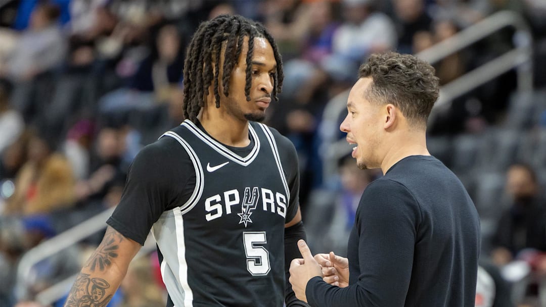 Mar 25, 2025; Detroit, Michigan, USA; San Antonio Spurs assistant coach Mitch Johnson talks to guard Stephon Castle (5) on a play stoppage against the Detroit Pistons during the first half at Little Caesars Arena. Mandatory Credit: David Reginek-Imagn Images