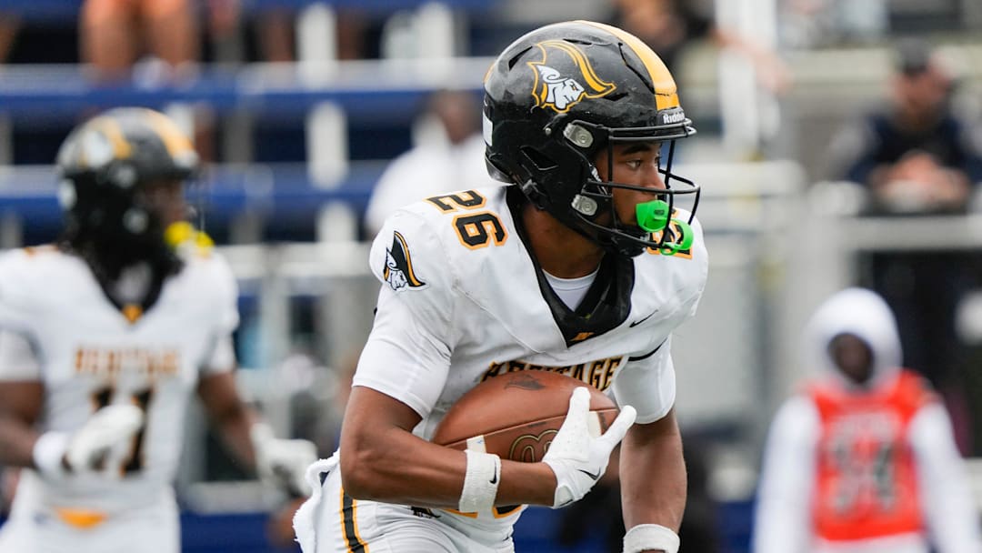 Tremaine Mullen (26) of American Heritage gains yardage in the FHSAA Class 4A state championship, Dec. 13, 2025, at Pitbull Stadium in Miami. American Heritage won 33-28.