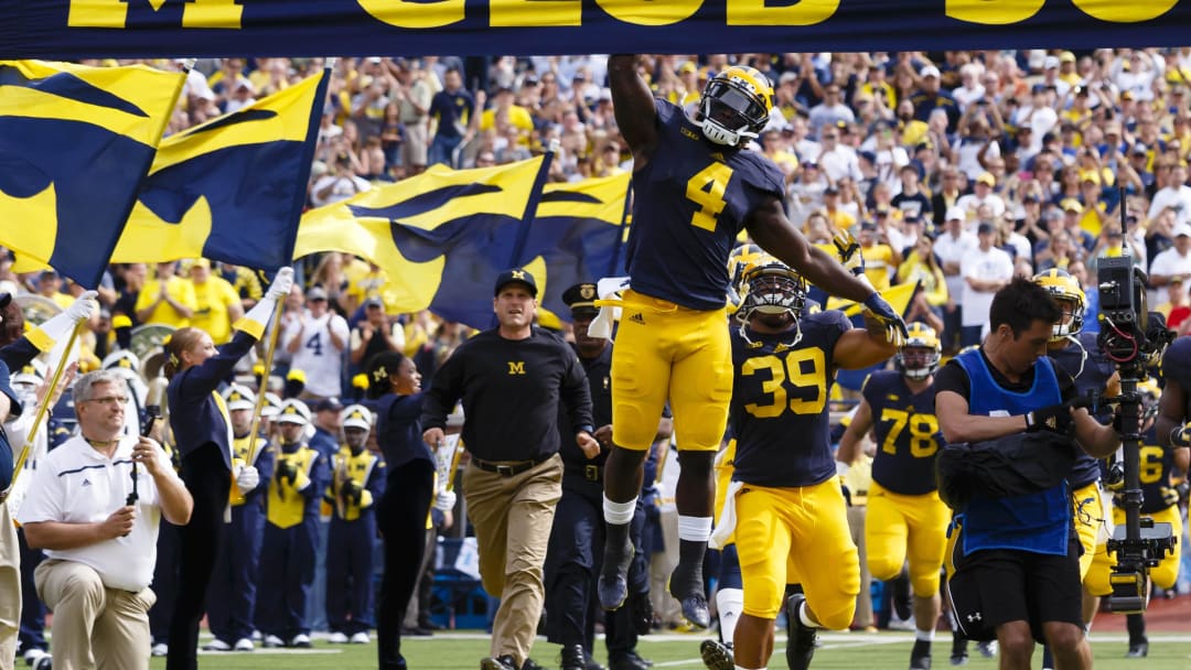 Sep 26, 2015; Ann Arbor, MI, USA; Michigan Wolverines running back De'Veon Smith (4) leads out the team with head coach Jim Harbaugh (left) prior to the game against the Brigham Young Cougars at Michigan Stadium. Mandatory Credit: Rick Osentoski-USA TODAY Sports