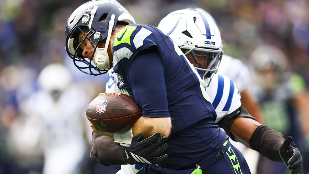 Dec 14, 2025; Seattle, Washington, USA; Indianapolis Colts safety Nick Cross (20) forces a fumble out of bounds by Seattle Seahawks quarterback Sam Darnold (14) during the second quarter at Lumen Field. 