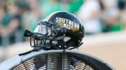 Oct 18, 2014; Denton, TX, USA; A Southern Miss Golden Eagles helmet atop a fan during the first quarter at Apogee Stadium. Southern Miss won 30-20. Mandatory Credit: Ray Carlin-USA TODAY Sports