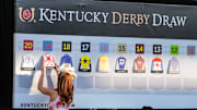 Miss Kentucky, Chapel Tinius, hangs horse cards the board to set the field for Kentucky Derby 2025 on opening night at Churchill Downs. Saturday, 26, 2025