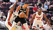 Oct 8, 2025; Miami, Florida, USA;  San Antonio Spurs center Victor Wembanyama (1) looks for room as Miami Heat center Bam Adebayo (13) and forward Andrew Wiggins (22) defend during the first half at Kaseya Center. Mandatory Credit: Jim Rassol-Imagn Images