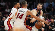 Dec 1, 2025; Miami, Florida, USA; Los Angeles Clippers center Ivica Zubac (40) makes a pass around Miami Heat guard Tyler Herro (14) and guard Norman Powell (24) during the first half at Kaseya Center. Mandatory Credit: Jim Rassol-Imagn Images