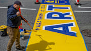 The painting of the 129th Boston Marathon start line in Hopkinton, April 16, 2025. Painter Matt Tobin of New Hampshire based Mission Turf Services puts down a yellow base coat.