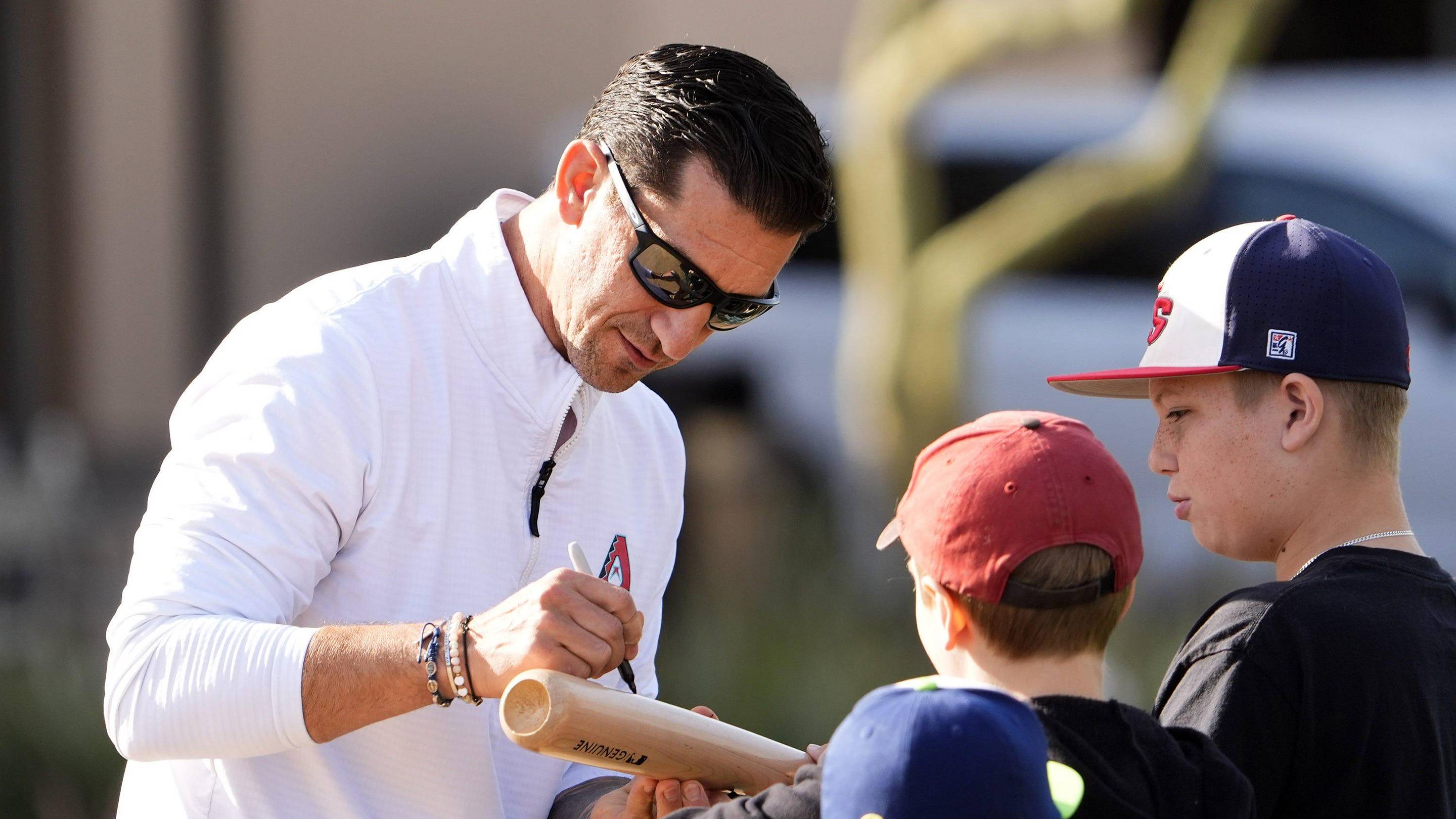 Arizona Diamondbacks Executive Vice President and General Manager Mike Hazen signs his autograph during spring training practice at Salt River Fields at Talking Stick on Feb. 12, 2025, in Scottsdale.