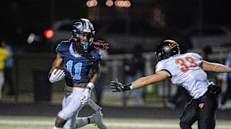 Guilford running back Messiah Tilson runs past Freeport's Riley Rushing during the first half of their game at Guilford High School in Rockford.