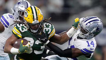 Green Bay Packers running back Aaron Jones (33) rushes against Dallas Cowboys safety Markquese Bell (14) during the first quarter of their wild card playoff game Sunday, January 14, 2024 at AT&T Stadium in Arlington, Texas.