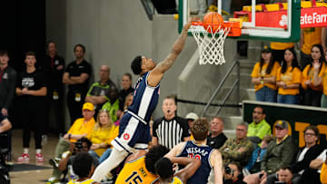 Feb 17, 2025; Waco, Texas, USA;  Arizona Wildcats guard Caleb Love (1) dunks the ball over Baylor Bears forward Norchad Omier (15) during the second half at Paul and Alejandra Foster Pavilion. Mandatory Credit: Chris Jones-Imagn Images