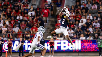 Sep 12, 2025; Tucson, Arizona, USA; Arizona Wildcats wide receiver Javin Whatley (6) catches the ball while Kansas State Wildcats defensive end Chiddi Obiazor (8) defends during the second quarter of the game at Arizona Stadium. Mandatory Credit: Aryanna Frank-Imagn Images