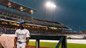 UCLA Bruins Dean West (36) sits in the dugout in the rain during a storm delay in the fourth inning against the LSU Tigers at Charles Schwab Field. Mandatory Credit: Dylan Widger—Imagn Images