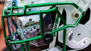 Oct 28, 2023; Houston, Texas, USA; The facemark of Tulane Green Wave defensive back Rayshawn Pleasant (25) reflects his teammates as he warms up before a game against the Rice Owls. Mandatory Credit: Thomas Shea-Imagn Images