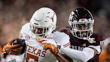 Nov 30, 2024; College Station, Texas, USA; Texas Longhorns wide receiver Ryan Wingo (5) carries the ball against Texas A&M Aggies defensive back Dezz Ricks (10) in the second quarter of the Lone Star Showdown game at Kyle Field. Mandatory Credit: Sara Diggins/USA TODAY Network via Imagn Images