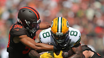 Green Bay Packers running back Josh Jacobs (8) is brought down by Cleveland Browns defensive end Joe Tryon-Shoyinka (90) and linebacker Carson Schwesinger (49) during the first half of an NFL football game at Huntington Bank Field, Sept. 21, 2025, in Cleveland, Ohio.