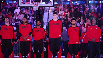 Dec 13, 2024; Portland, Oregon, USA; Portland Trail Blazers center Donovan Clingan (23) stands in the middle with teammates during the singing of the national anthem before a game against the San Antonio Spurs at Moda Center. Mandatory Credit: Troy Wayrynen-Imagn Images