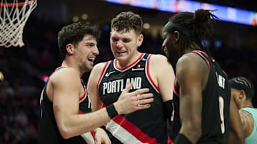 Feb 22, 2025; Portland, Oregon, USA; Portland Trail Blazers center Donovan Clingan (23) and forward Jerami Grant (9) celebrate with forward Deni Avdija (8) during the second half against the Charlotte Hornets at Moda Center. Mandatory Credit: Troy Wayrynen-Imagn Images