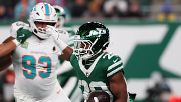 New York Jets running back Breece Hall (20) runs with the ball while being pursued by Miami Dolphins defensive tackle Calais Campbell (93) during the second quarter at MetLife Stadium last season.