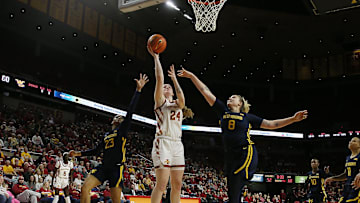 Iowa State Cyclones forward Addy Brown (24) takes a shot between West Virginia Mountaineers guard Lauren Fields (23) and forward Danelle Arigbabu (8) during the fourth quarter in the Big-12 conference matchup at Hilton Coliseum on Wednesday, Jan. 10, 2024, in Ames, Iowa.